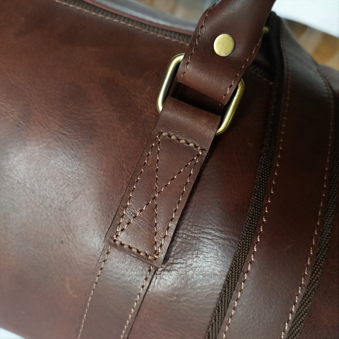 Bolso de viaje de cuero marrón en tono oscuro