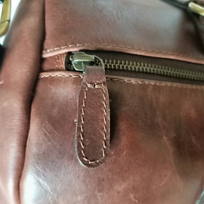 Bolso de viaje de cuero marrón en tono oscuro